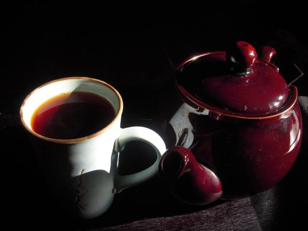 Filled Cup of Tea with Tea Kettle